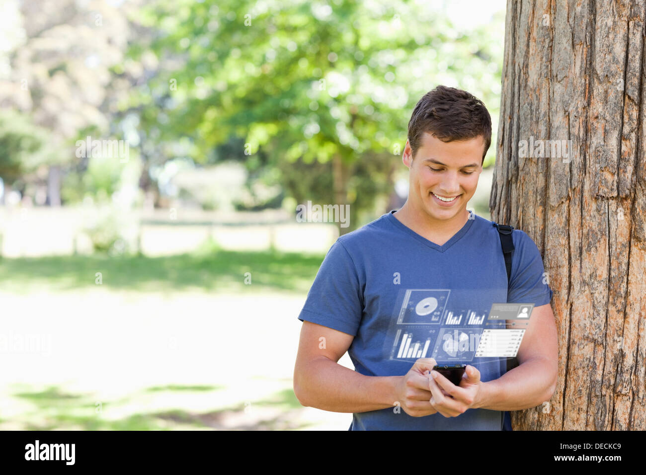 Smiling handsome student using his digital smartphone Stock Photo