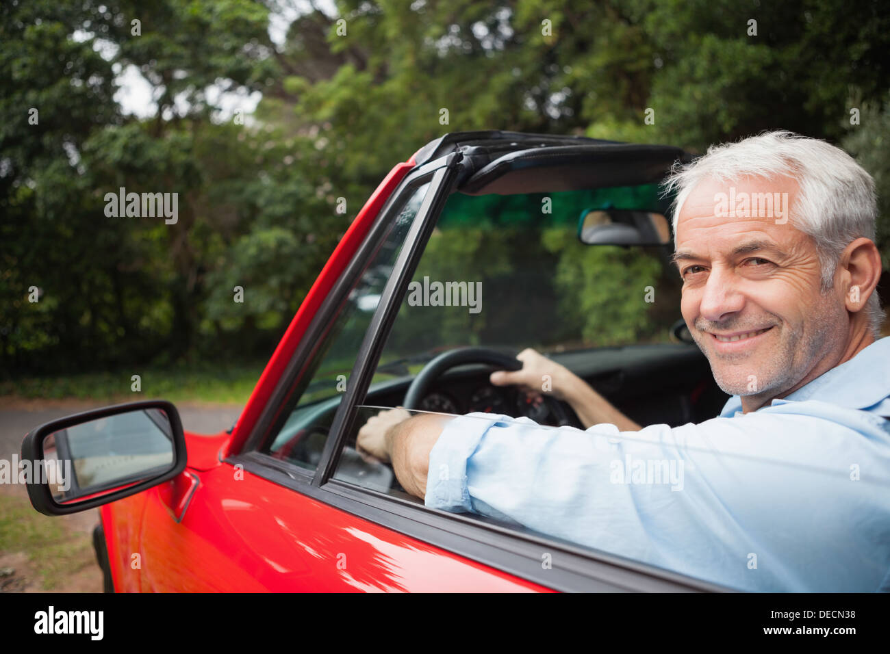 Smiling handsome man driving red cabriolet Stock Photo