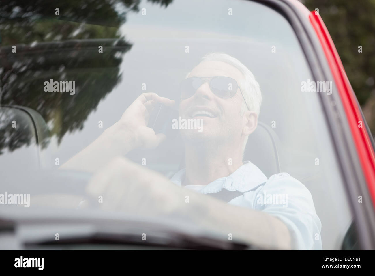 Smiling handsome man in red convertible having phone call Stock Photo