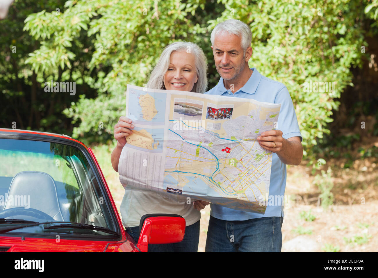 Smiling mature couple reading map Stock Photo