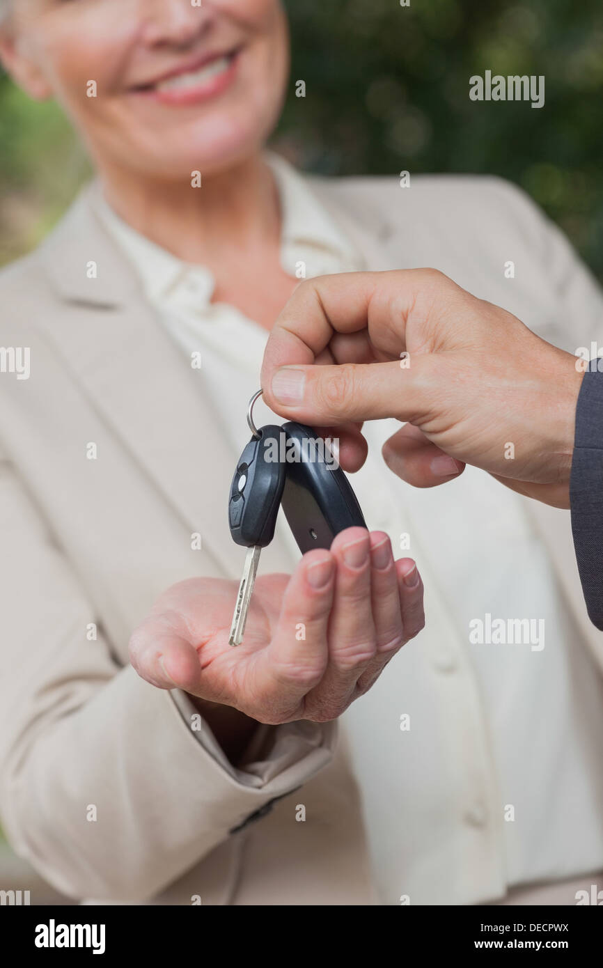 Close up on smiling businesswoman being given keys Stock Photo - Alamy