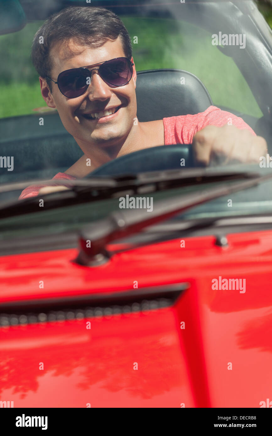 Cheerful handsome man driving his cabriolet Stock Photo