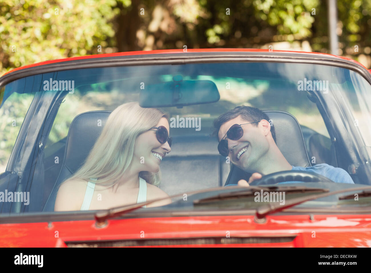 Loving couple in their red cabriolet having a ride Stock Photo - Alamy