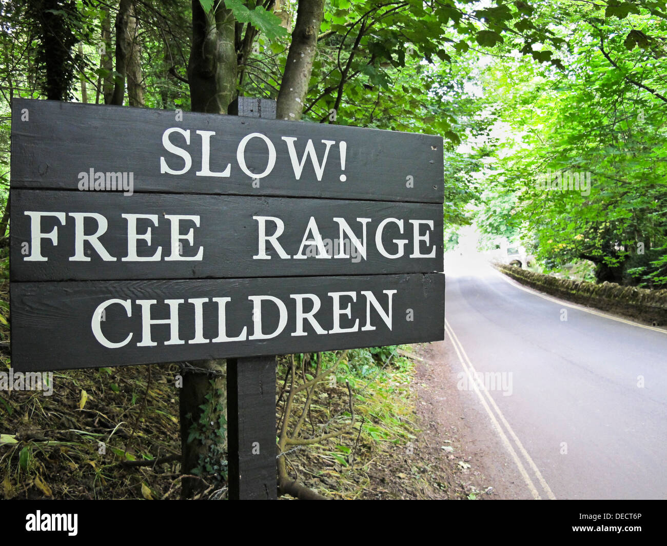 'Slow! Free Range Children' road safety sign in Castle Combe. Wiltshire, UK Stock Photo