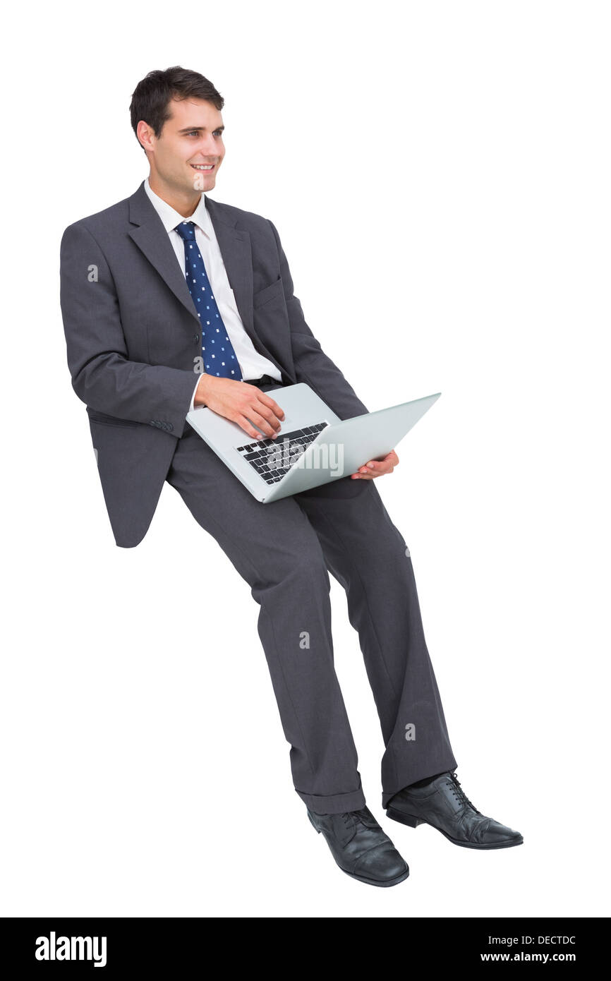 Smiling businessman sitting using a laptop Stock Photo
