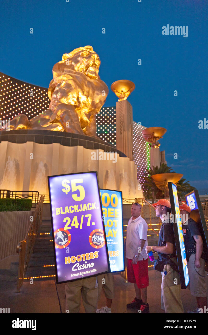 Portable illuminated advertising screens beside Leo the Lion bronze statue at MGM Grand, Las Vegas, Nevada, USA at dusk. JMH5409 Stock Photo