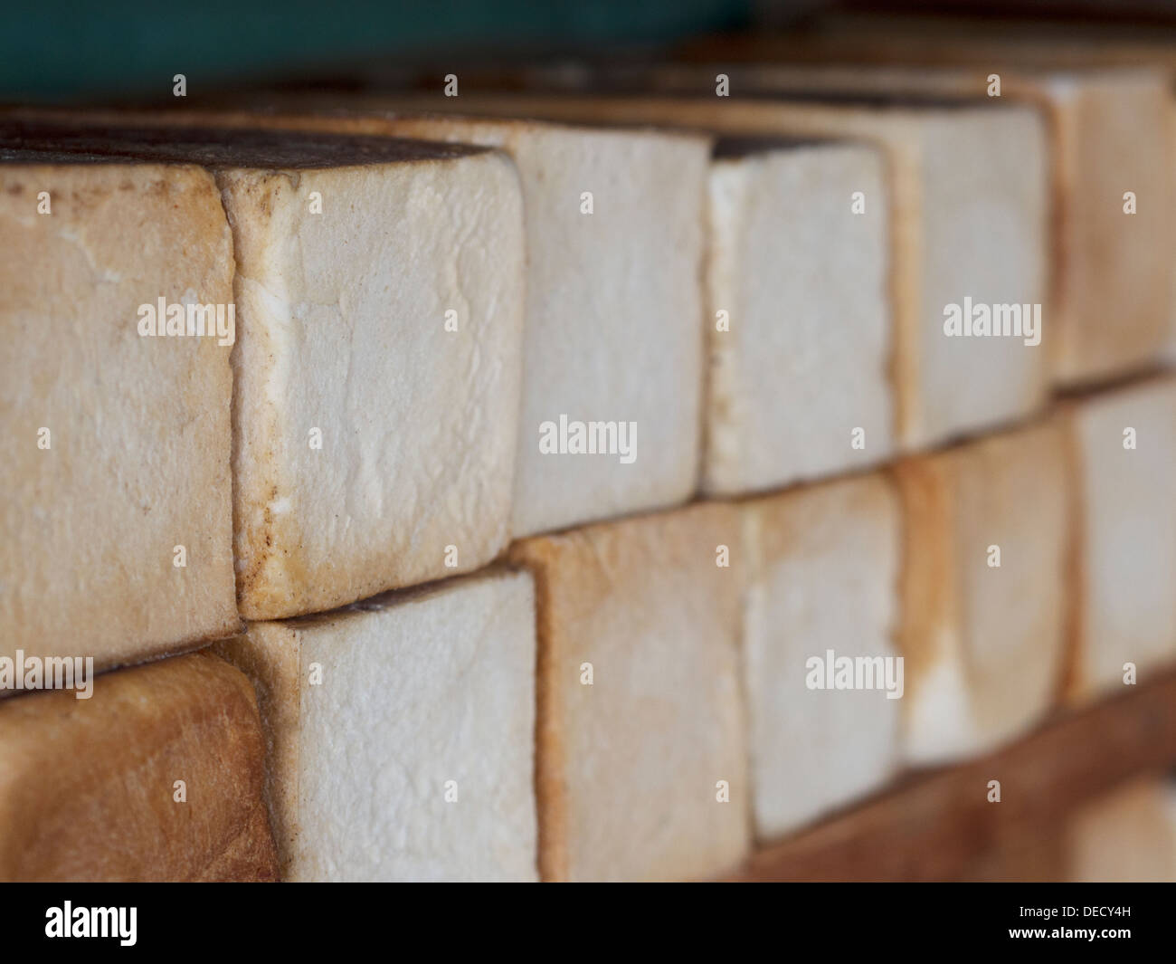 Rustic, unsliced loaves of bread on a bakery shelf. Stock Photo