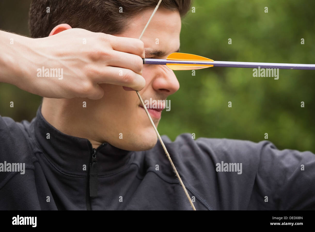 Concentrated man practicing archery Stock Photo