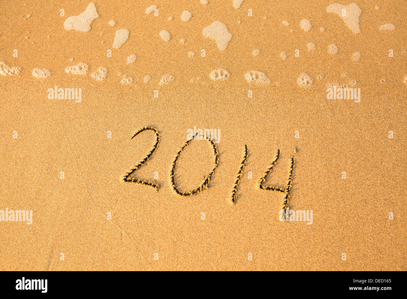 2014 - written in sand on beach texture, soft wave of the sea Stock ...
