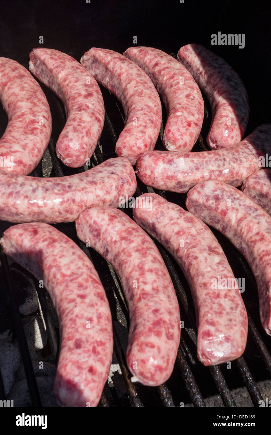 Raw brats laid out to cook on an outdoor grill. USA. Stock Photo