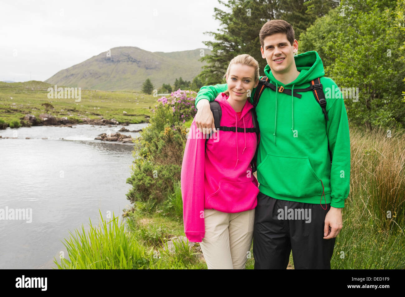 Athletic couple in hooded jumpers on a hike Stock Photo