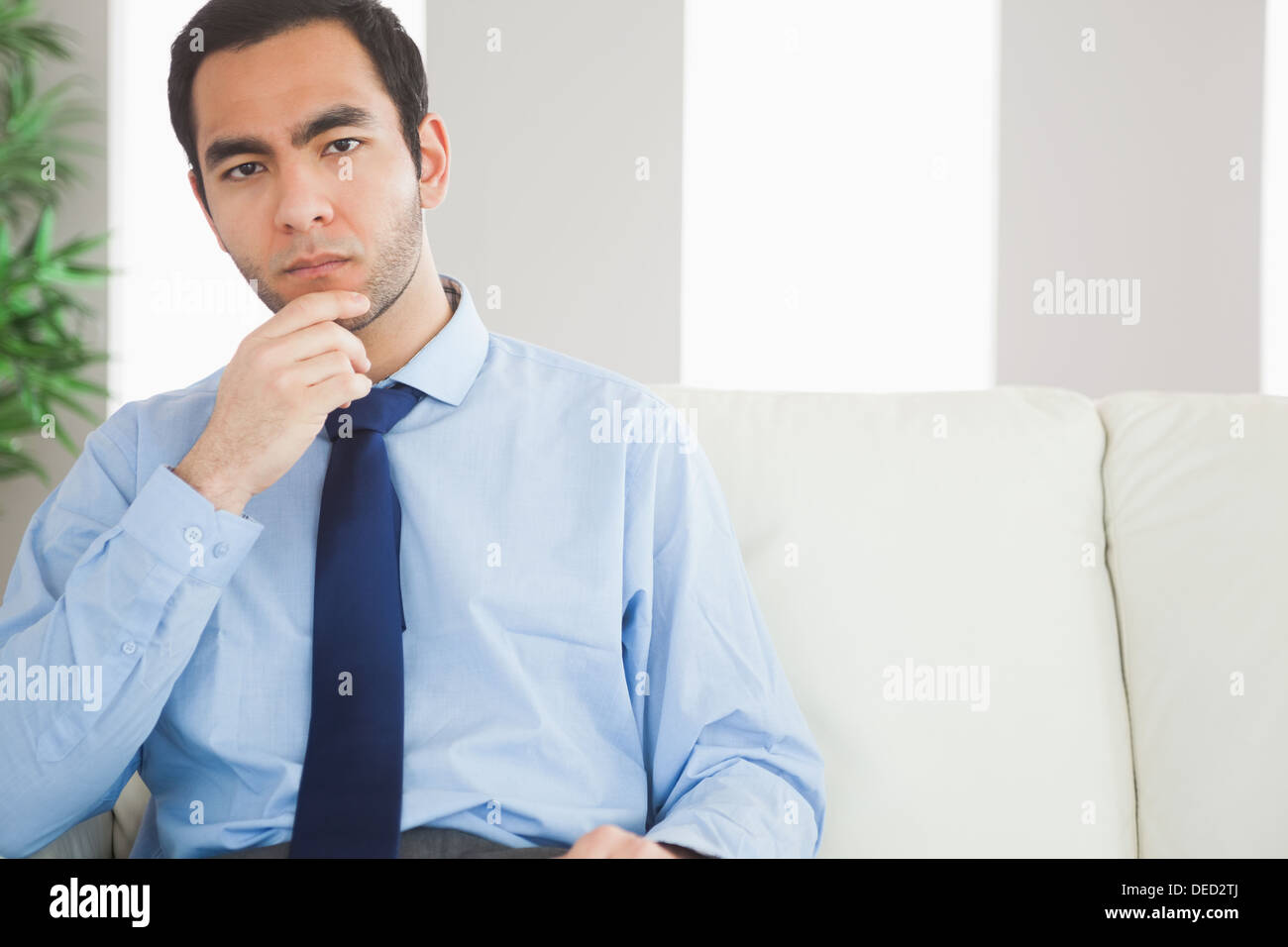 Thoughtful classy businessman sitting on cosy sofa Stock Photo