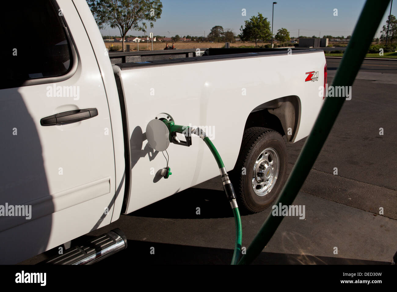 Chevy truck filling up with diesel fuel at gas station - USA Stock Photo