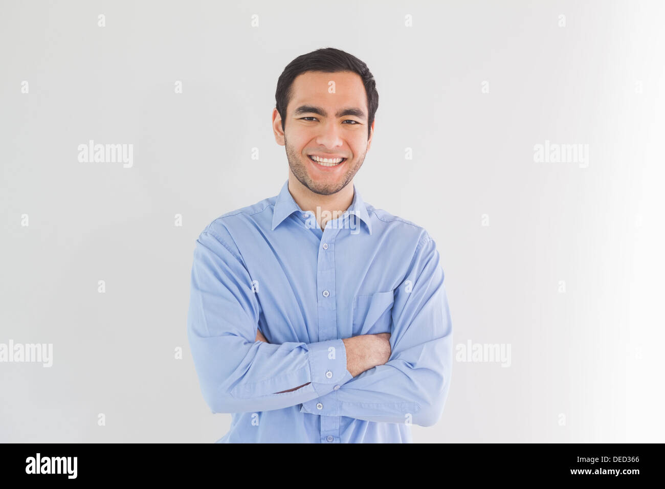 Smiling man standing with arms crossed and looking Stock Photo