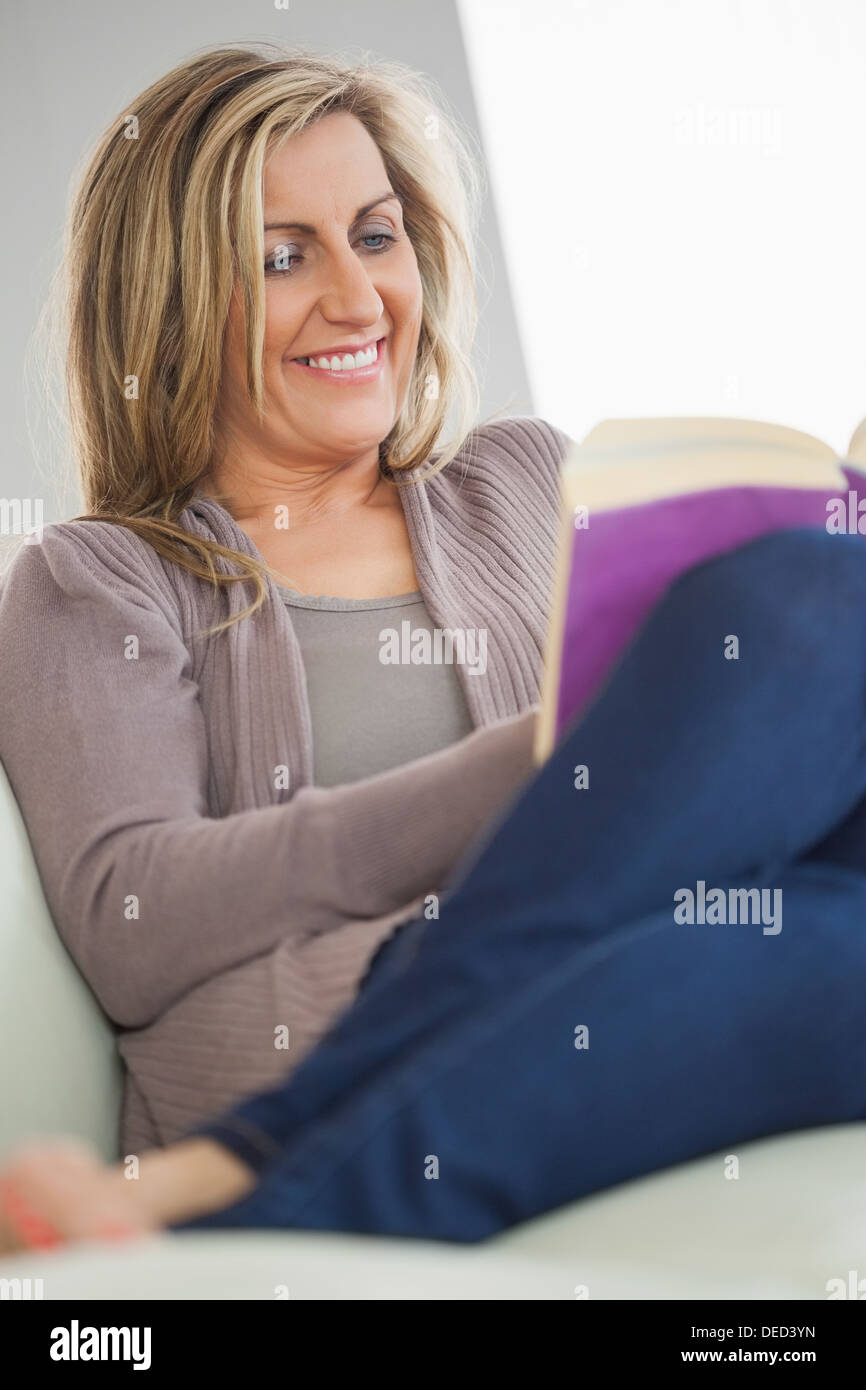 Smiling woman reading a book Stock Photo