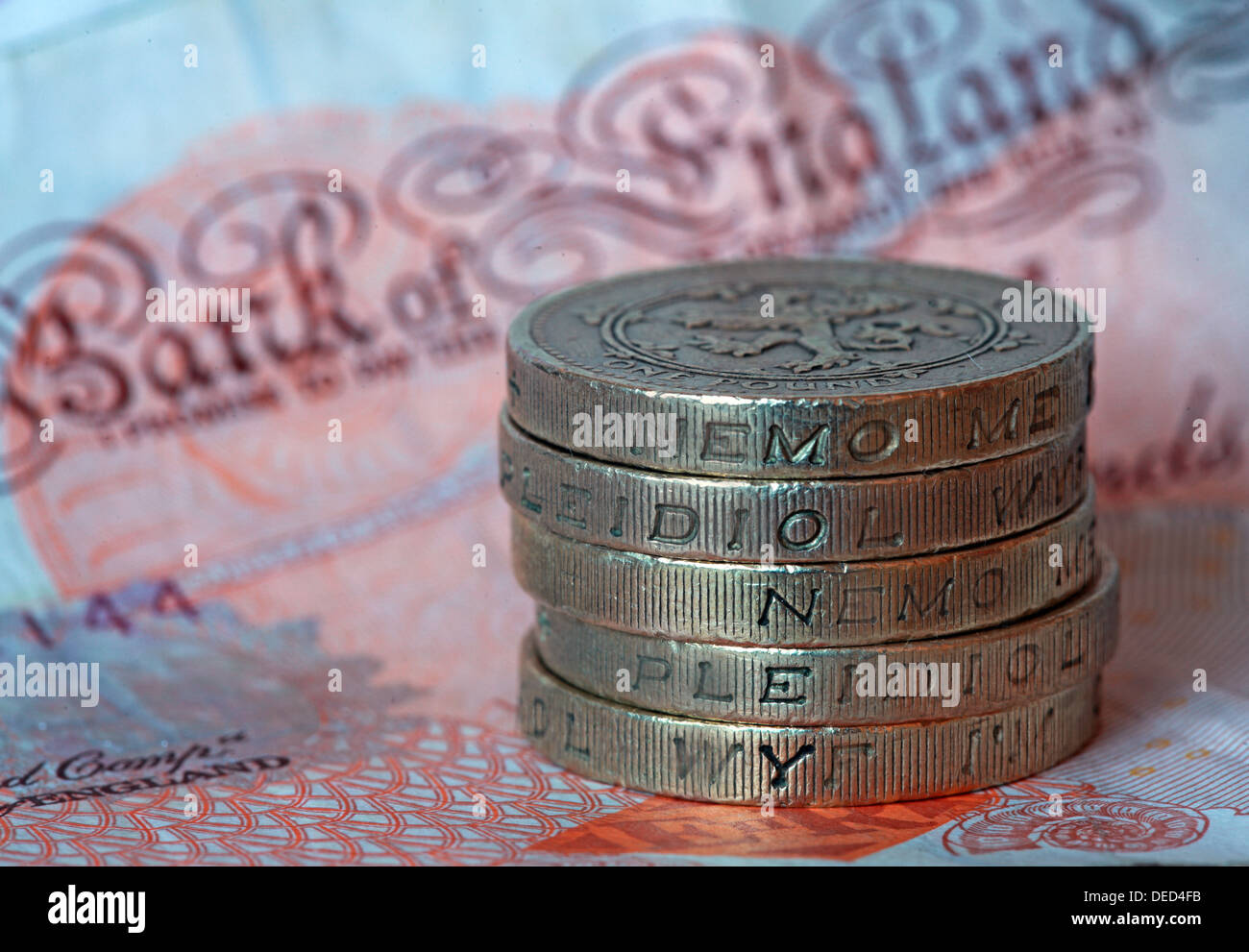 British Sterling Pound coins stacked spelling 'Money' sitting on a UK £10 note Stock Photo