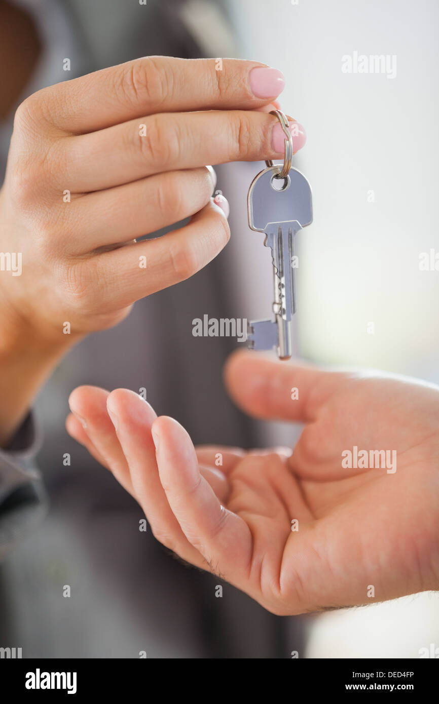 Estate agent giving house key to customer Stock Photo