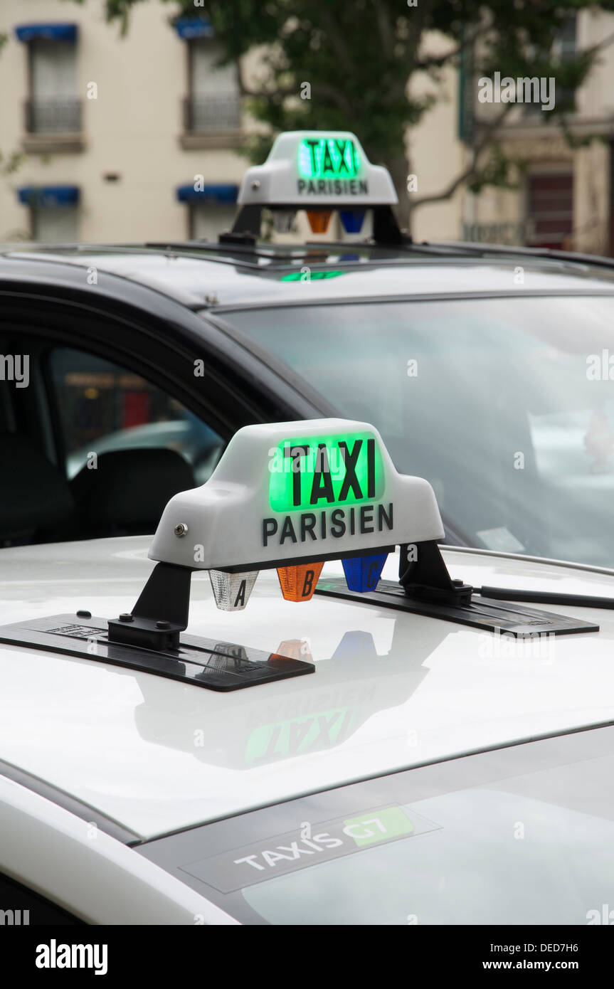 French public transport. The illuminated roof signs of two Parisian taxi cabs, waiting for their next fare. Paris, France. Stock Photo