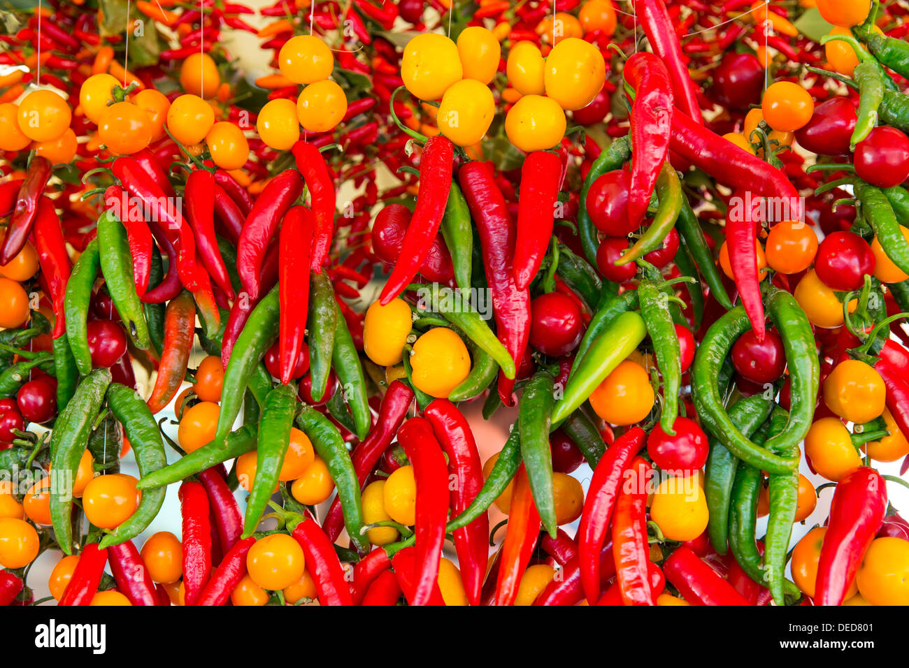 RED AND GREEN HOT PEPPERS AND TOMATOES ON A MARKET STALL NEXT TO THE ...