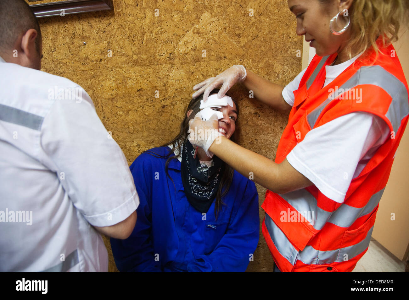 Red Cross people attending injured woman during ´correfoc´ traditional festival, La Bisbal d´Emporda, Baix Emporda, Costa Stock Photo
