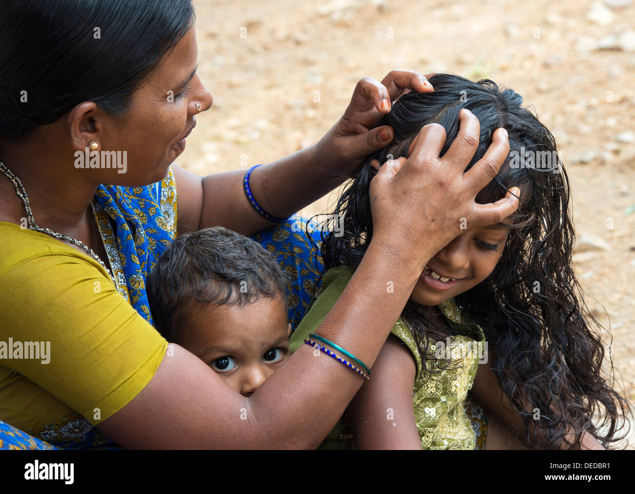 Indian mother nitpicking young girls head in a rural indian village. Andhra Pradesh, India Stock Photo