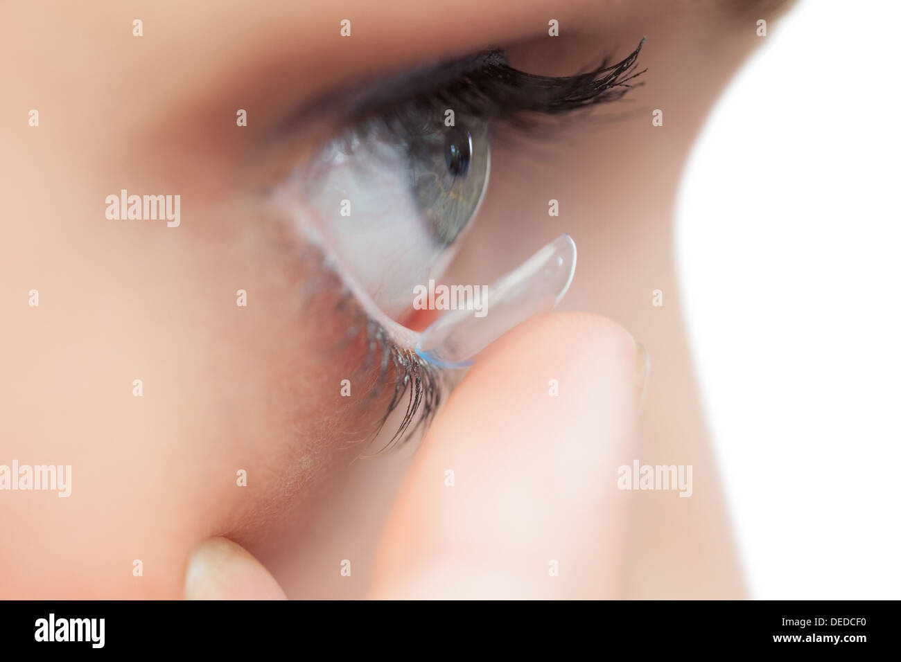 Extreme close up on young model applying contact lens Stock Photo