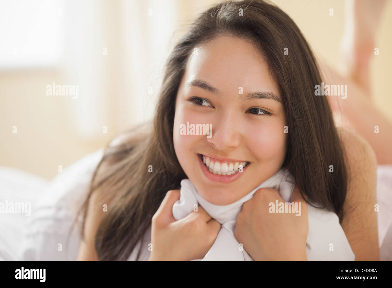 Cute young asian woman holding her duvet and smiling Stock Photo