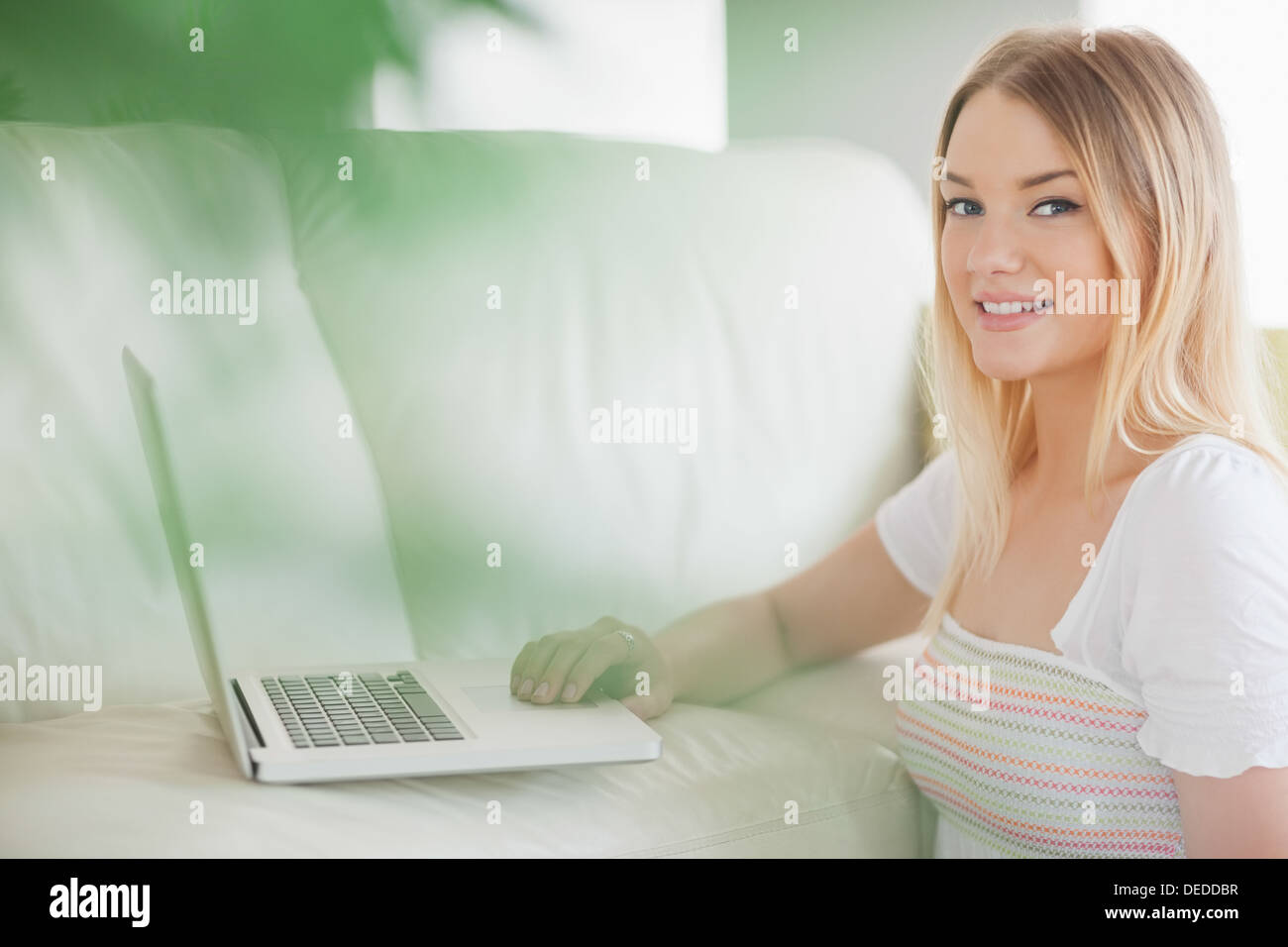 Smiling woman using laptop sitting on floor Stock Photo