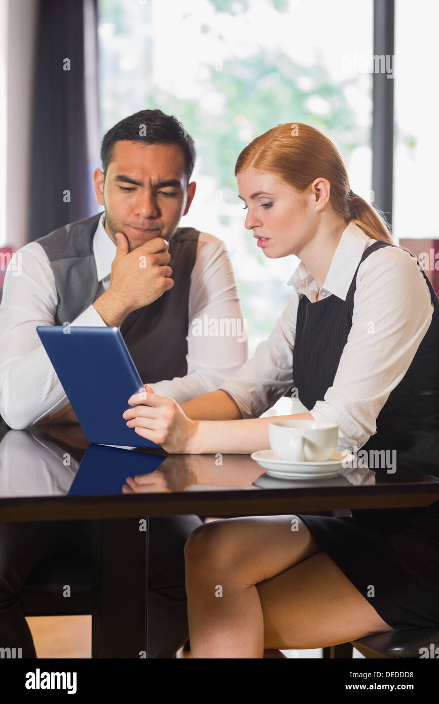 Business partners working on tablet pc together in a cafe Stock Photo