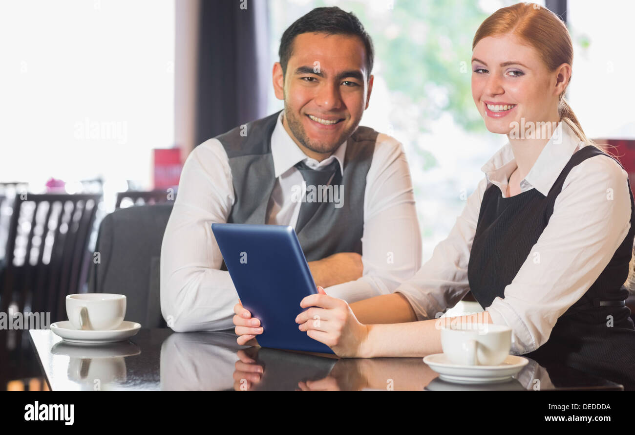 Business team working on tablet pc together in a cafe Stock Photo
