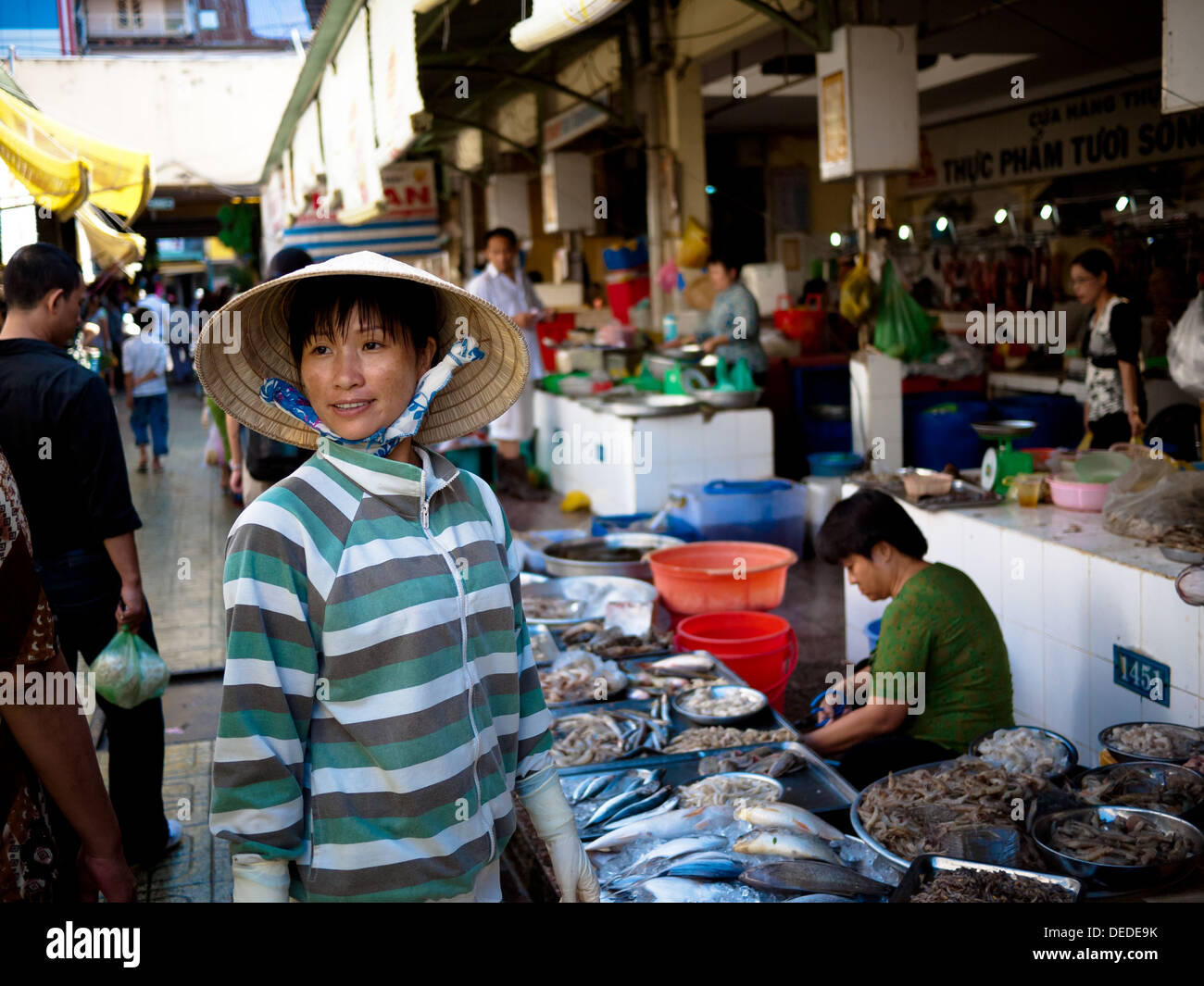 A Vietnamese woman in a conical hat at a street market in Ho Chi Minh City (Saigon), Vietnam. Stock Photo