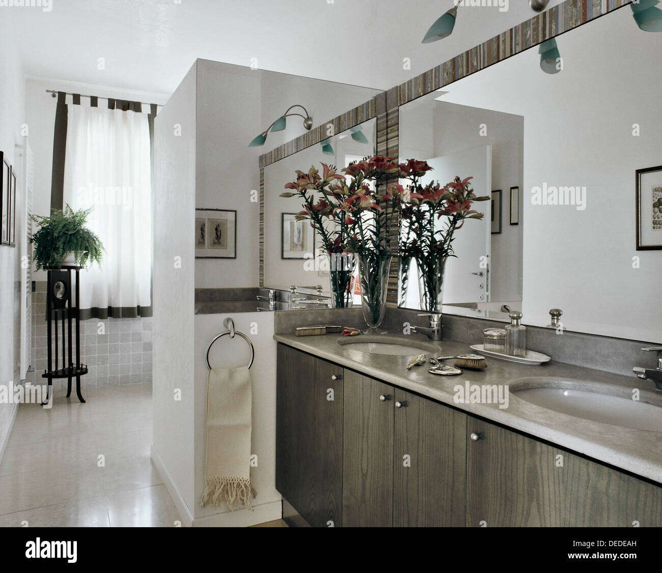 modern bathroom with marble top and vase of flowers Stock Photo