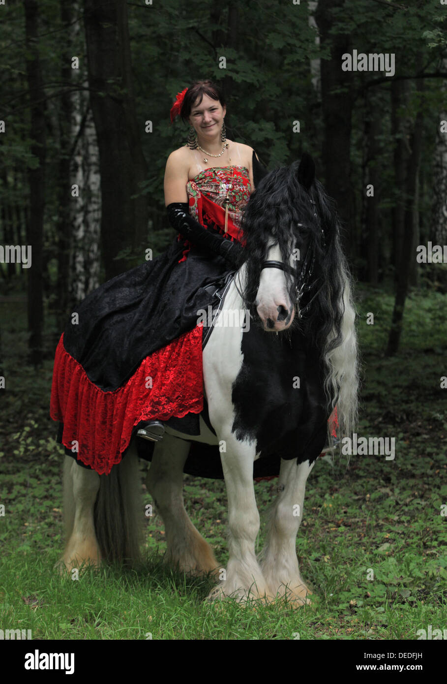 Beautiful gypsy woman with horse in woods Stock Photo