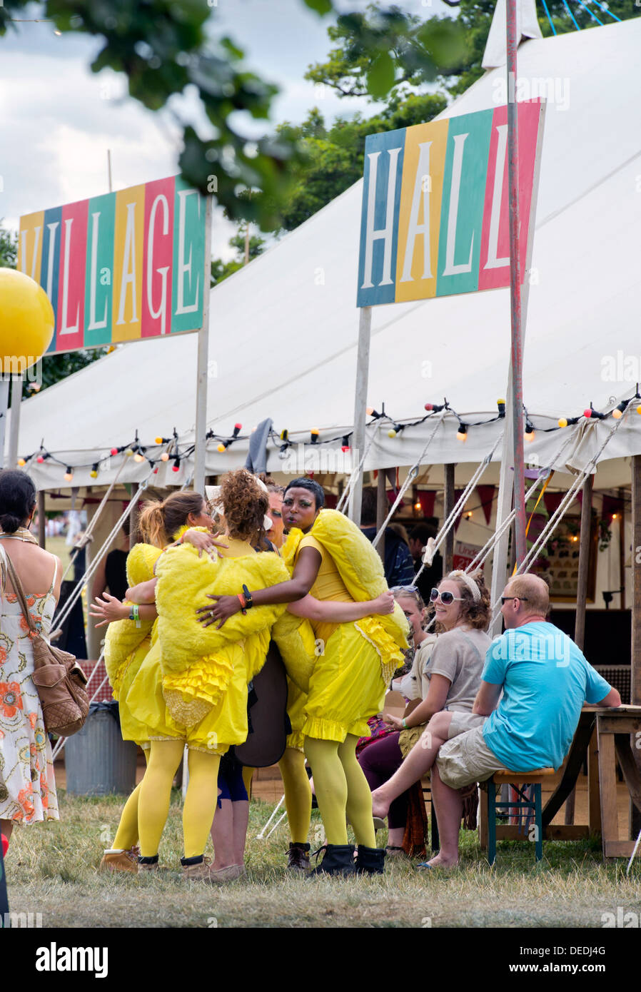 A theatre group dressed as chicks hug a visitor at the Wilderness Festival at Cornbury Park Oxfordshire, UK Stock Photo
