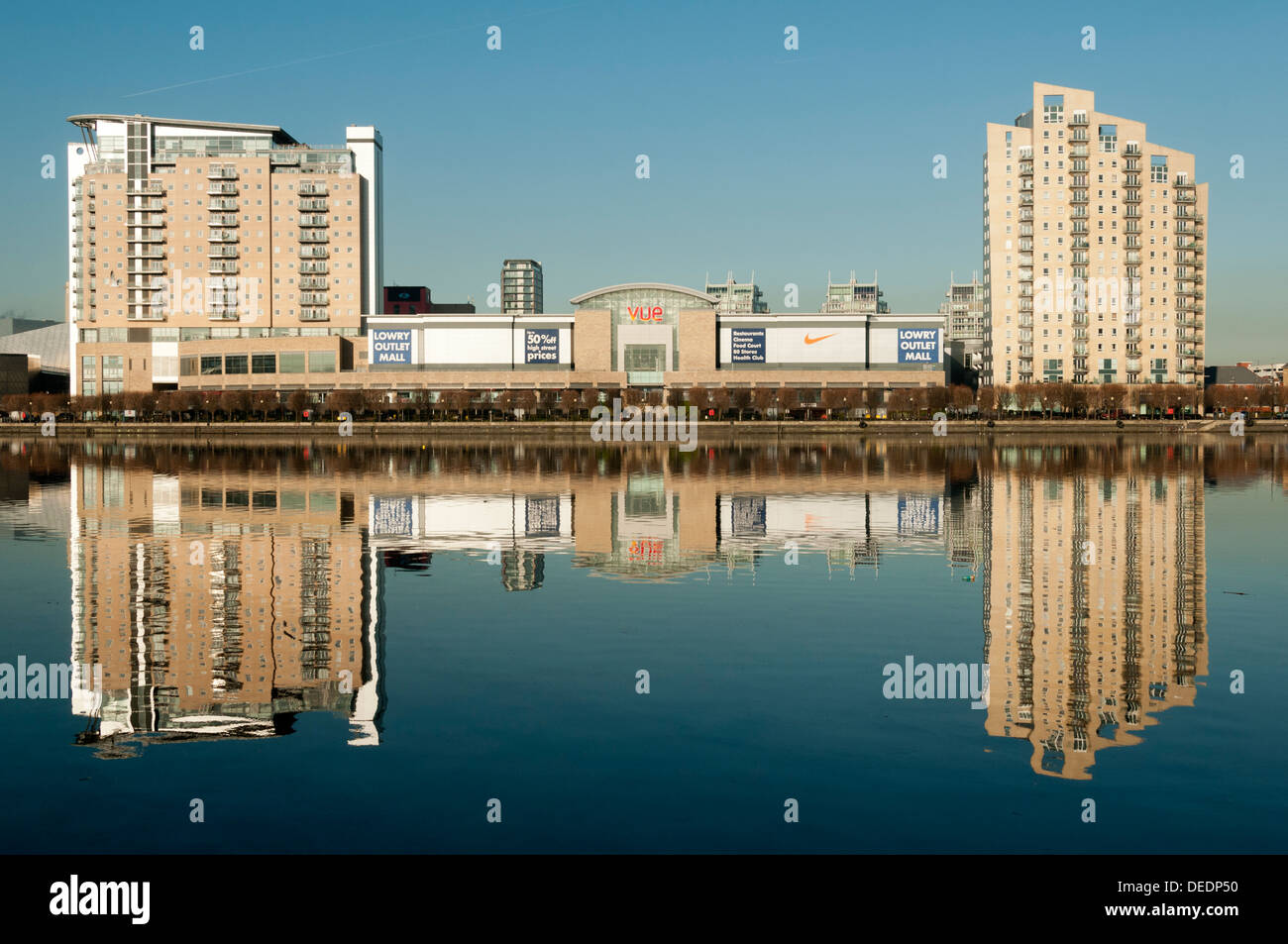 Imperial Point, Sovereign Point apartment bloc and the Lowry Outlet Mall reflected in Salford Quays, Manchester, England, UK Stock Photo