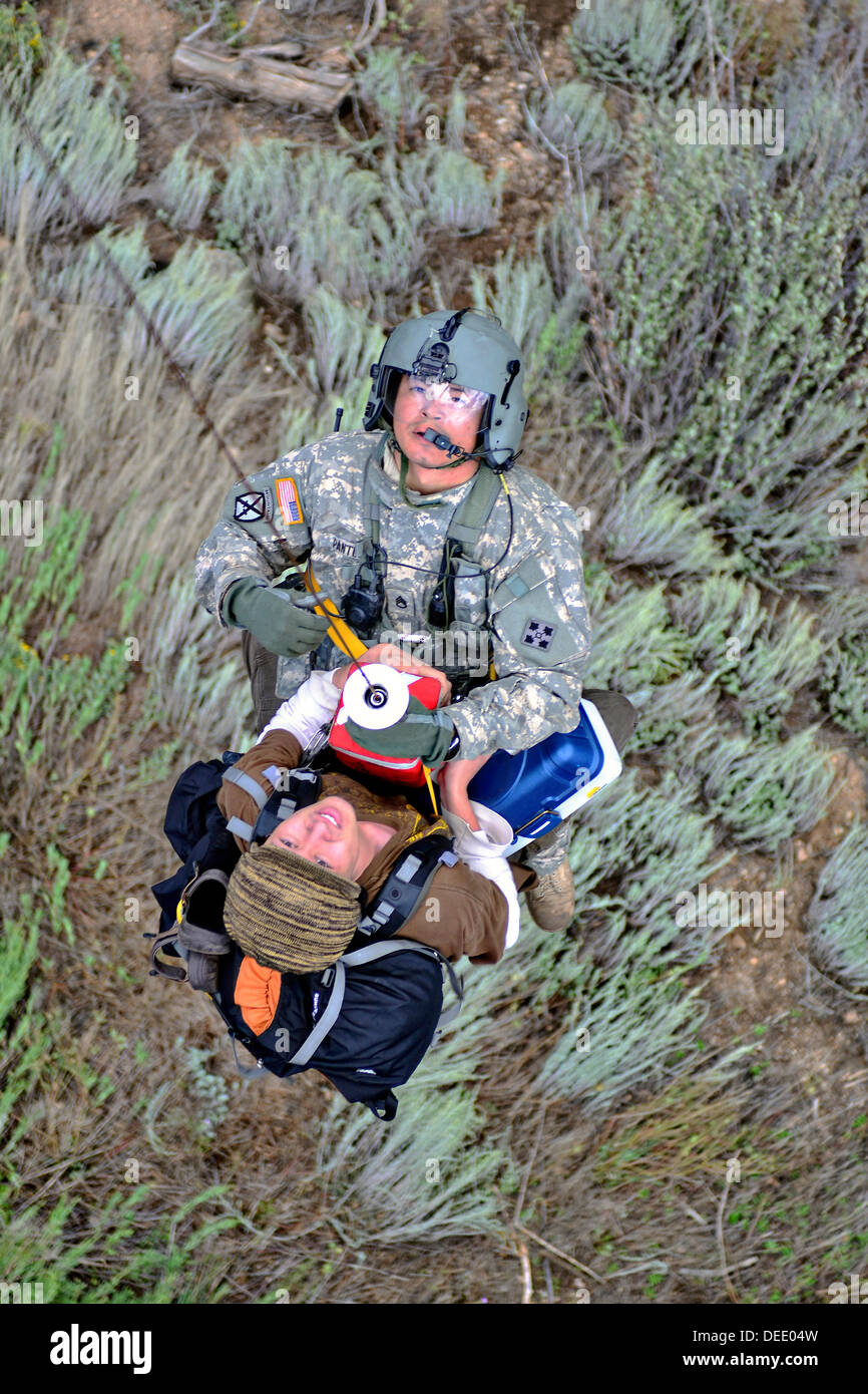 A US Air Force Flight Medic rescues a stranded resident with a hoist on to a UH-60 Black Hawk medevac helicopter during a flood rescue and recovery operations following severe flooding September 16, 2013 in Boulder, Colorado. Stock Photo