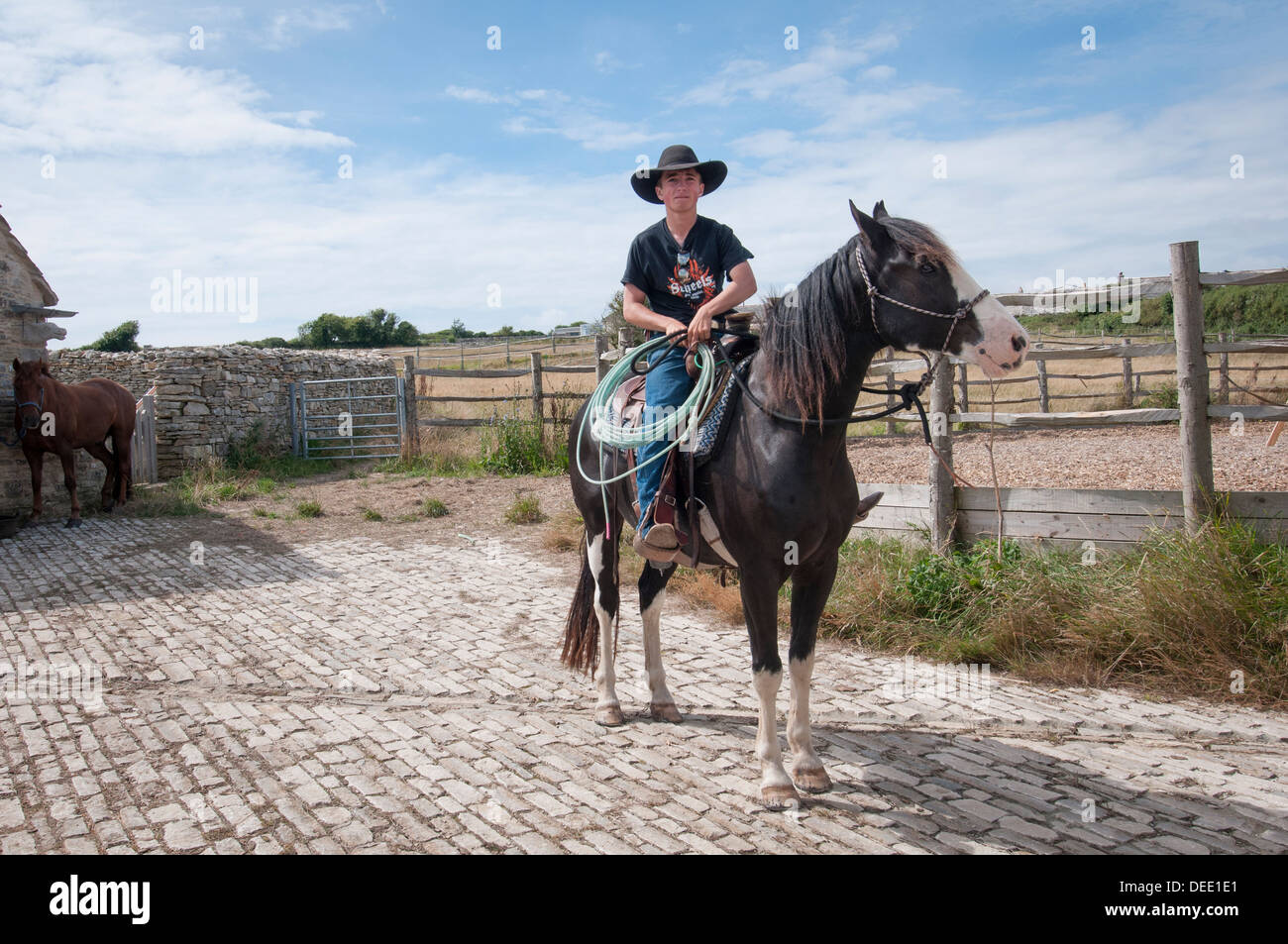 young cowboy sitting on a horse with a lasso Stock Photo