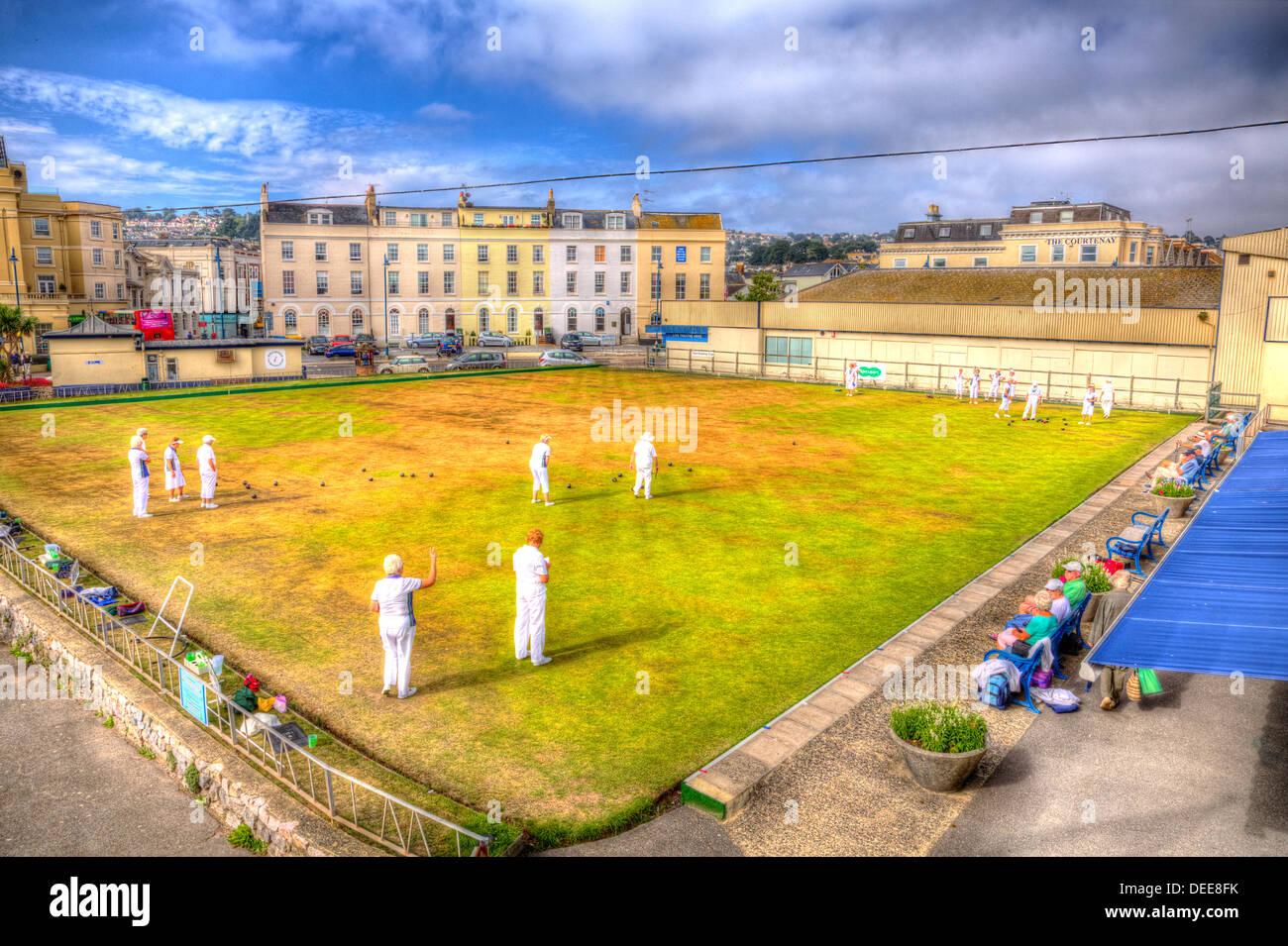 Ladies playing bowls summer day with blue sky and white clouds in HDR, English game played on green lawn Stock Photo