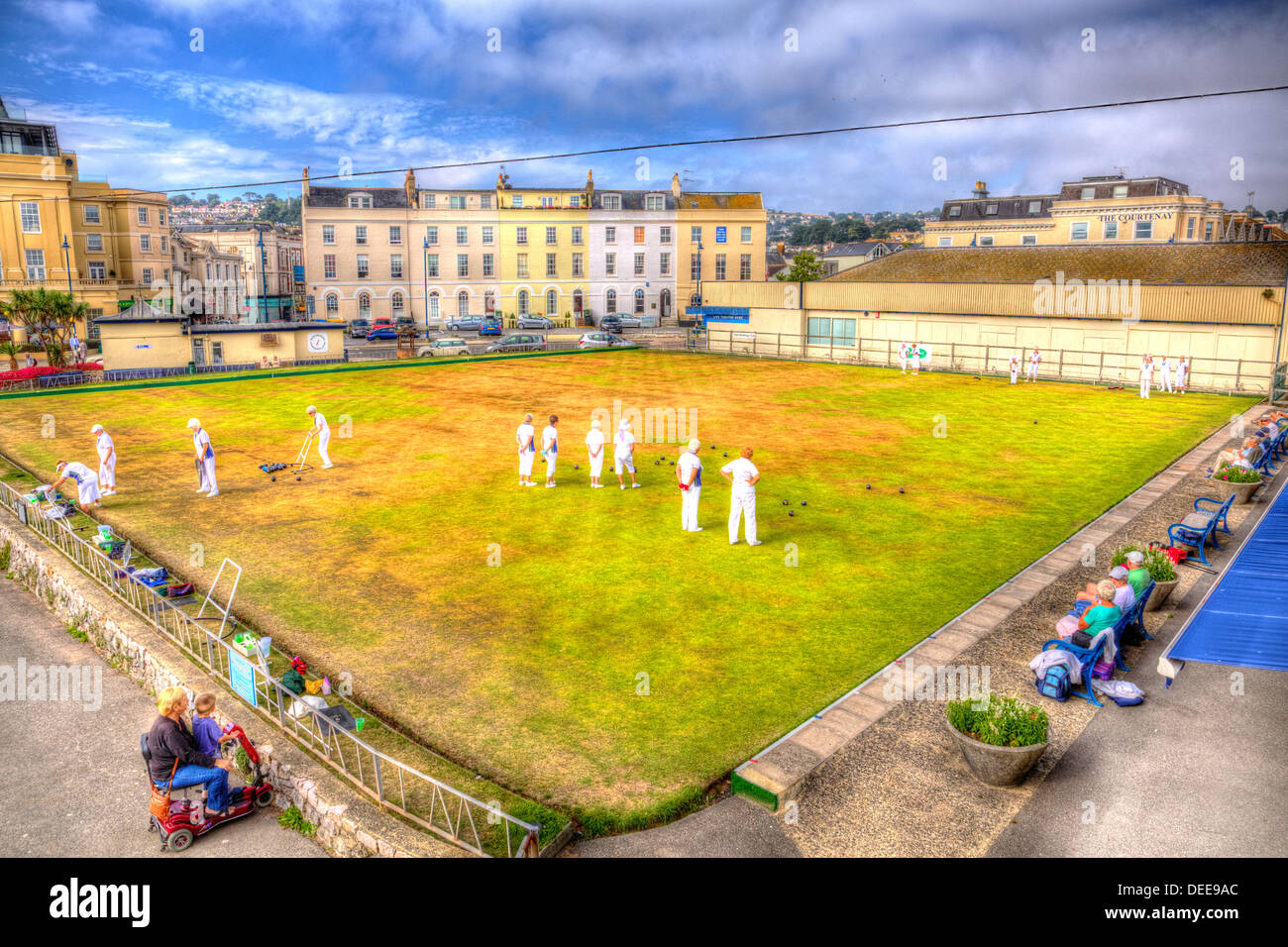 Ladies playing bowls summer day with blue sky and white clouds in HDR, English game played on green lawn Stock Photo