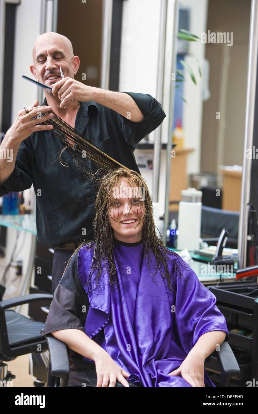 Male Hairdresser Cutting Hair To Woman At Beauty Salon Stock Photo