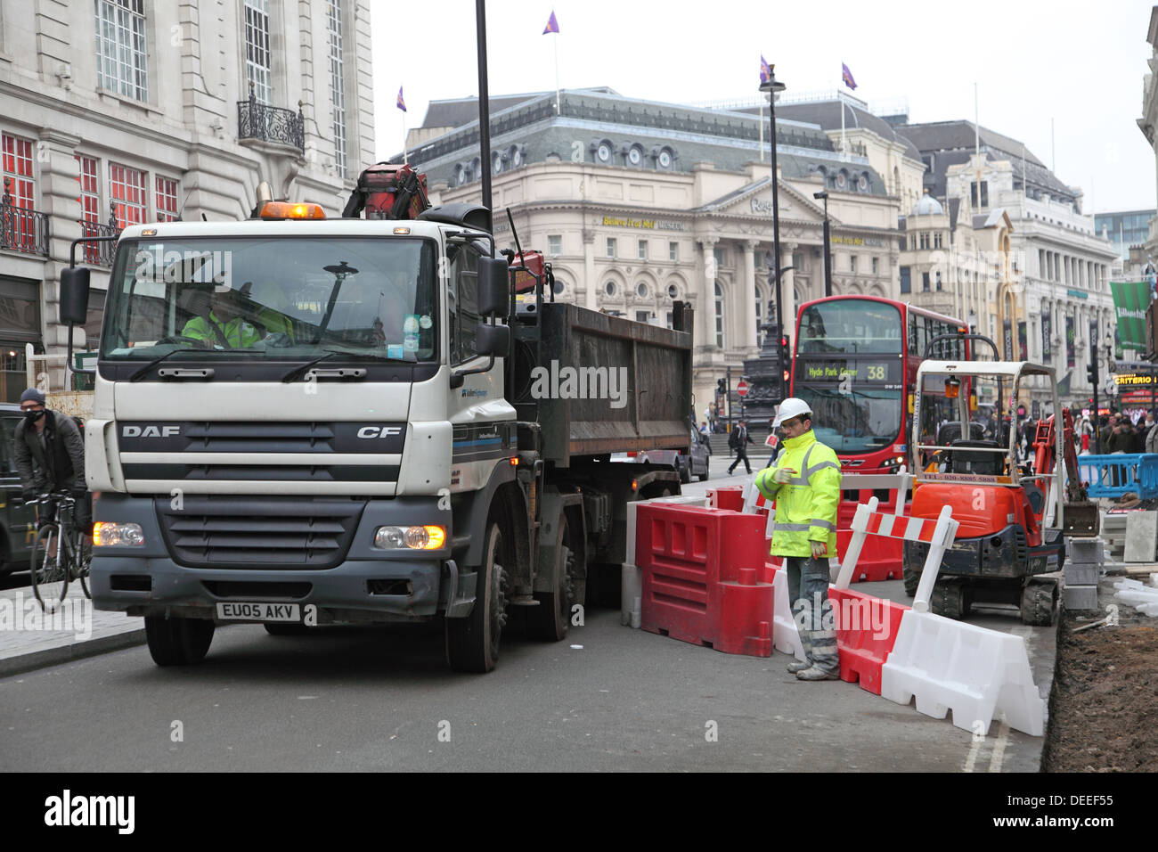 A lorry is maneuvered into place as roadworks cause disruption to traffic and pedestrians on London's Piccadilly Stock Photo