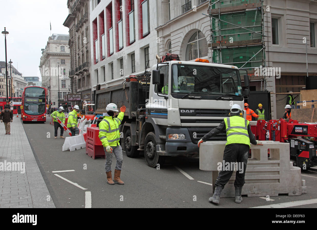 A lorry is maneuvered into place as roadworks cause disruption to traffic and pedestrians on London's Piccadilly Stock Photo