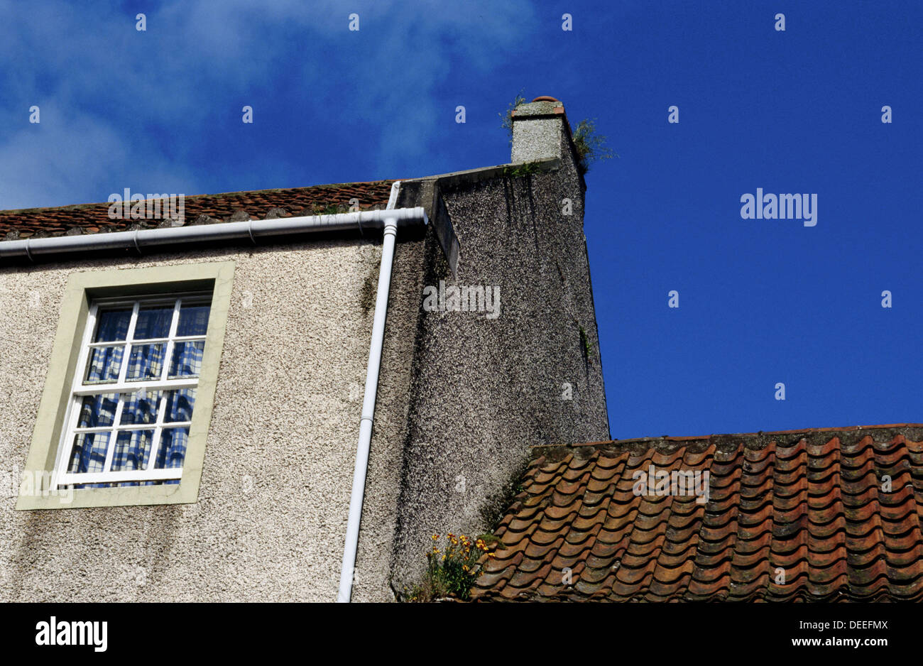 Red tiled roof and flowers in gutter. Crail. Scotland Stock Photo