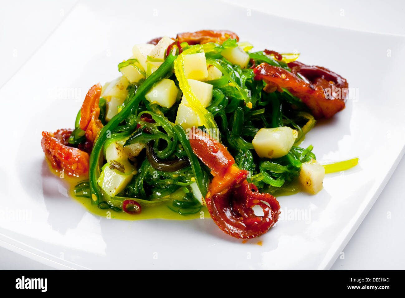 Salad with octopus, scallop and Hiyashi Wakame on a white plate. Stock Photo