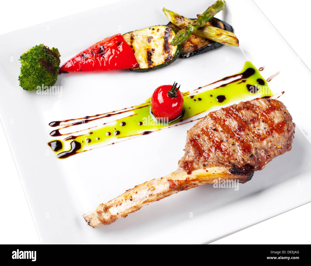 Grilled meat and vegetables on a white plate. Stock Photo