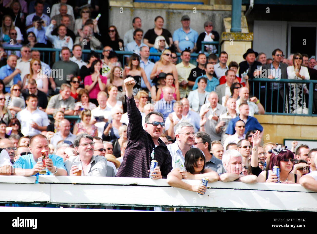 Crowd of people watching, drinking and some people winning during horse racing Stock Photo