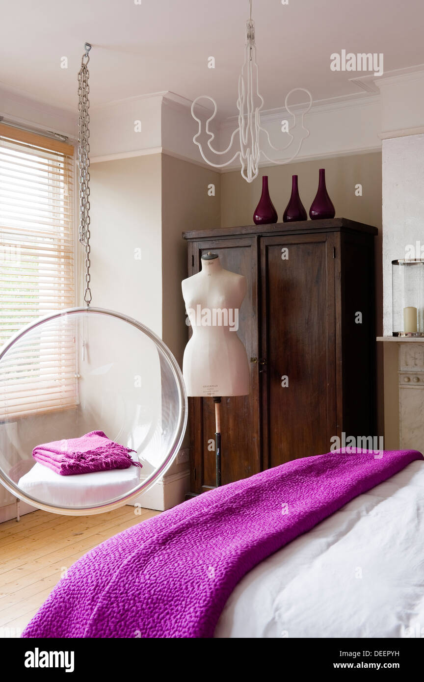 Mannequins dummy and antique wardrobe in bedroom with pink accent and Eero Aarnio bubble chair Stock Photo