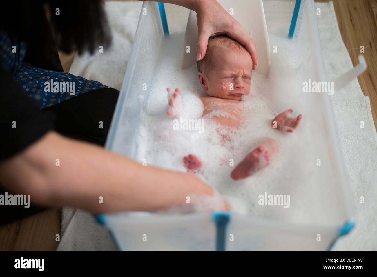 A newborn baby boy getting bathed by his mother. Stock Photo