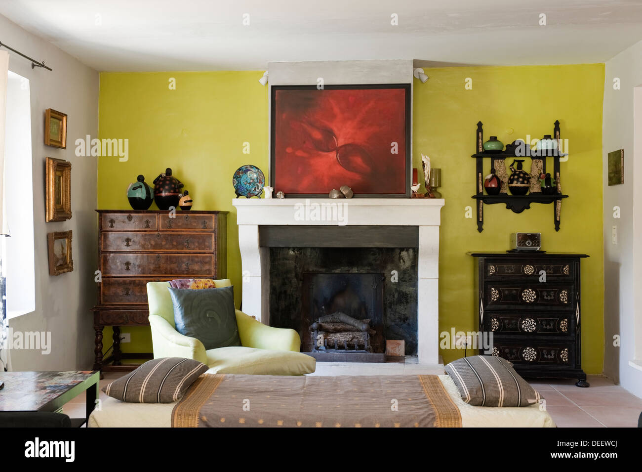 Low daybed near fireplace with centre throw from Sri Lanka. Two antique chests, one Anglo