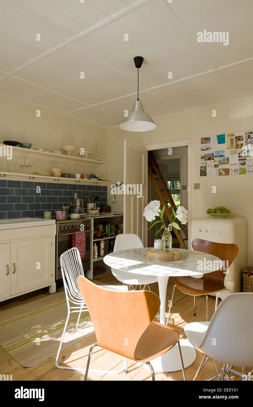 Pedestal base kitchen table with mismatched chairs Stock Photo Alamy